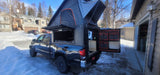 Black Toyota Tacoma with an Alucab pop-up truck camper and rooftop tent, showing an RV rental setup ready for adventure.