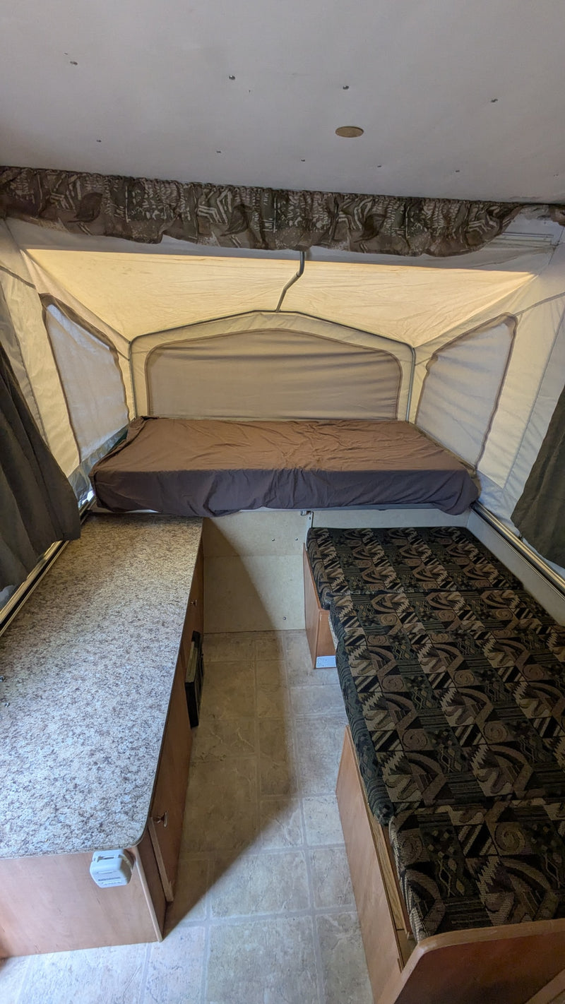  expanded and ready. Perfect rv rental for outdoor adventures.|Inside an rv rental pop-up camper featuring a bed — photo 2