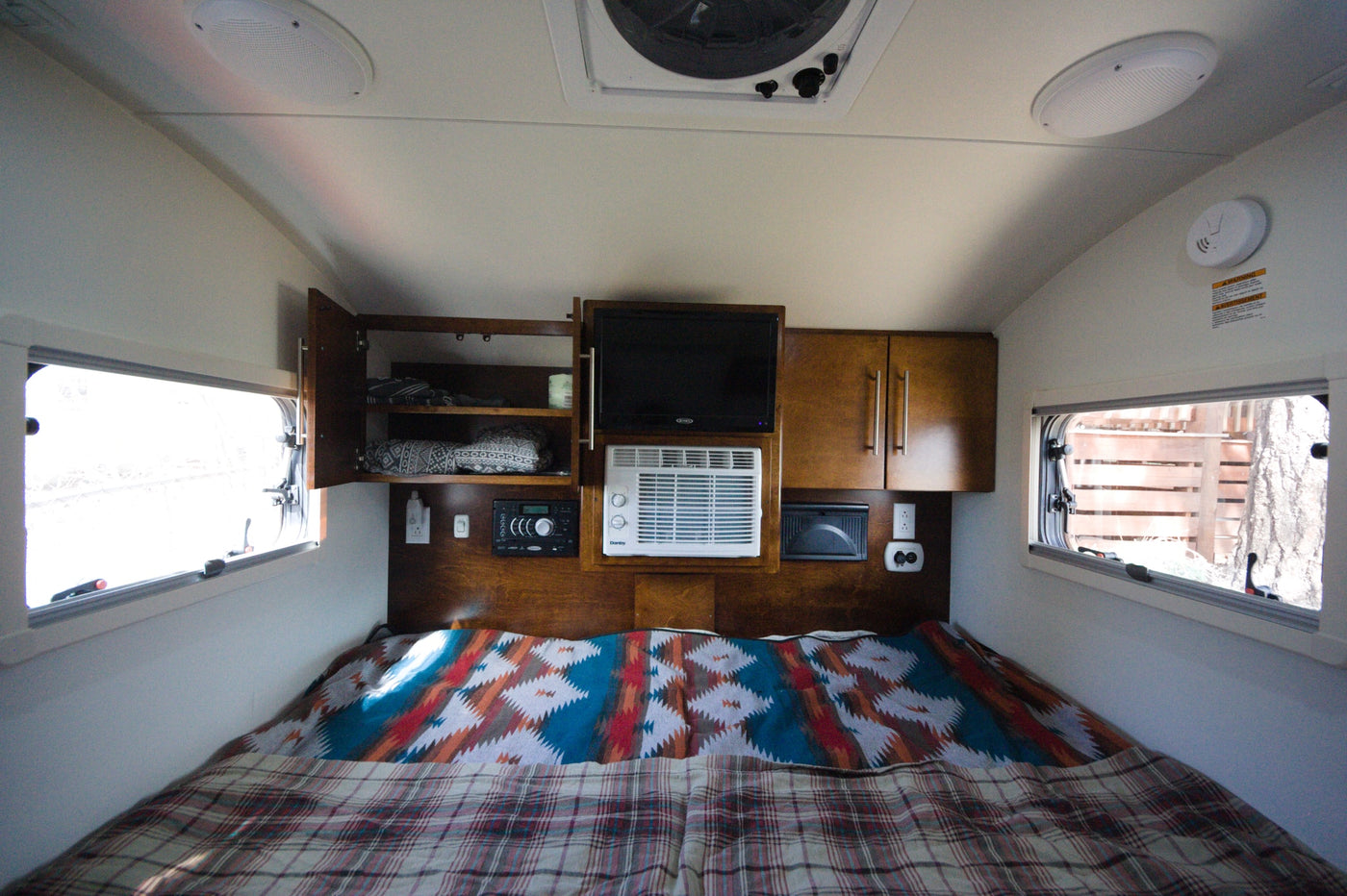 Cozy rv rental interior: a comfortable bed, TV, AC, and ample storage cabinets make for ideal travel accommodations. — photo 10