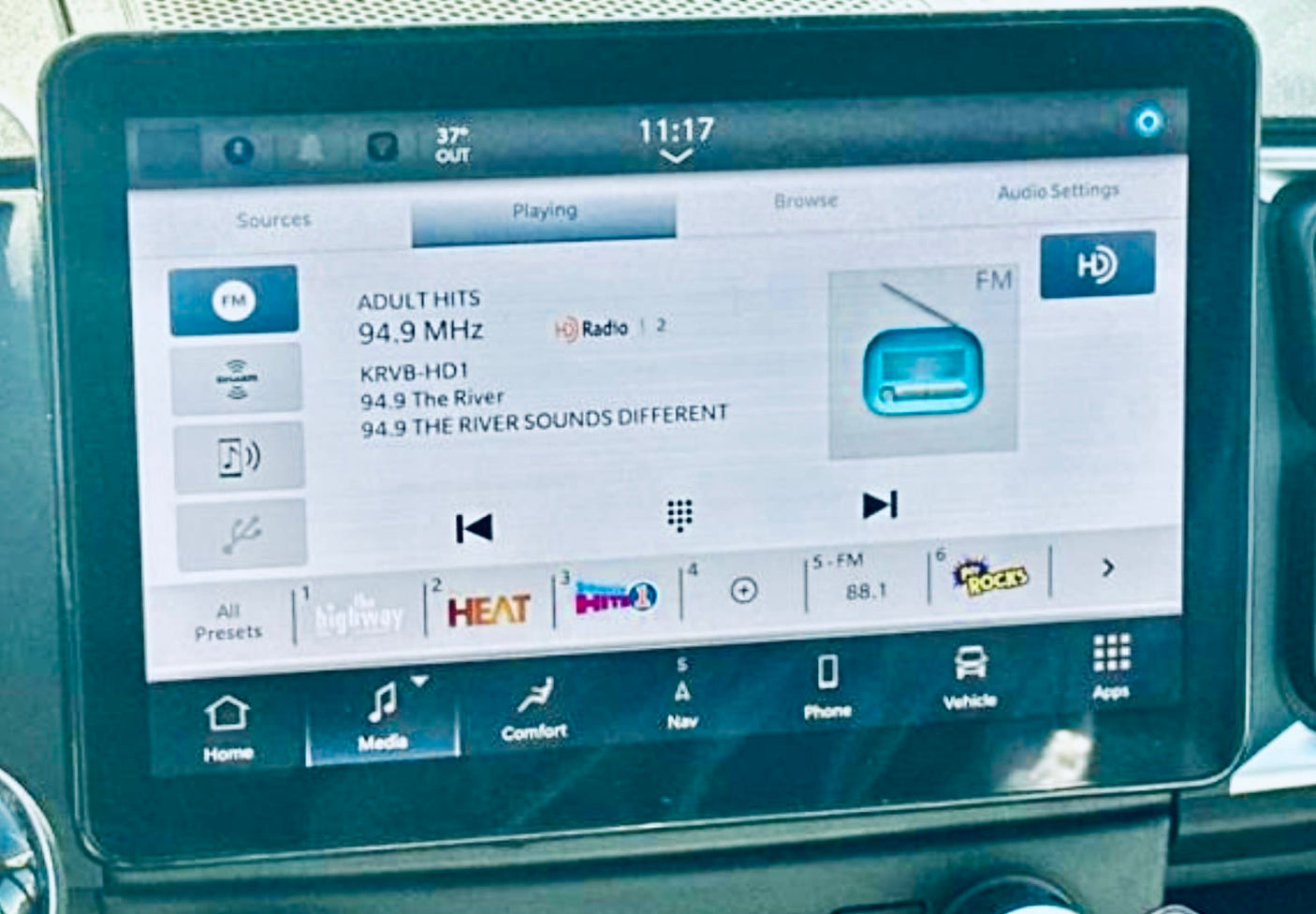 An rv rental vehicle's infotainment screen shows radio 94.9 MHz, 11:17, 37°F, & navigation menu.