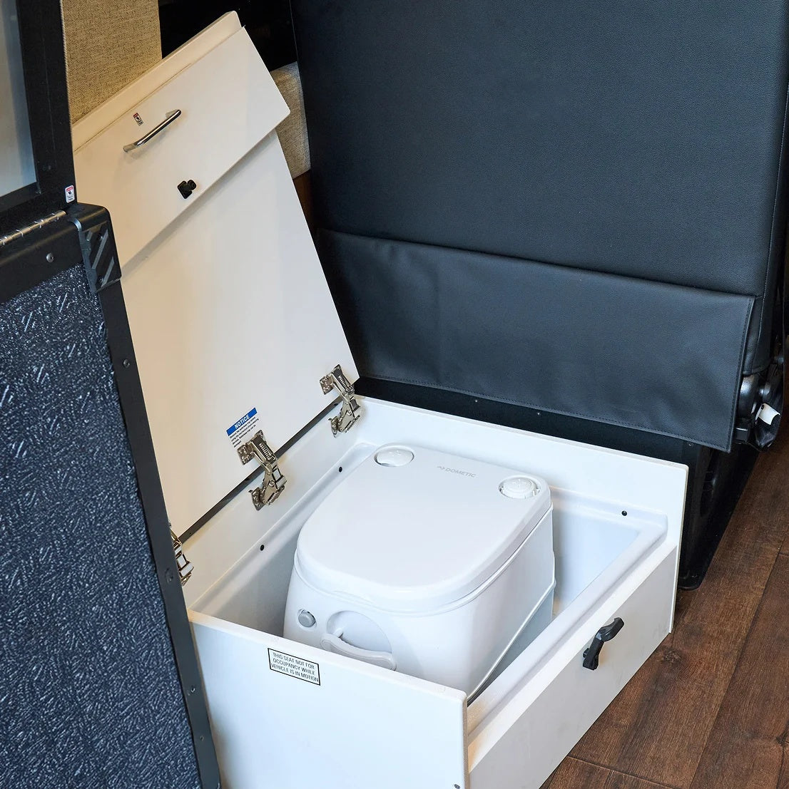 RV rental: A Dometic portable toilet is neatly stored in a pull-out compartment under a seat for compact convenience.
