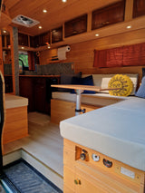 Step inside this custom wood RV rental. Features a cozy kitchen, dining, and sleeping area with smart storage and amenities for mobile living.