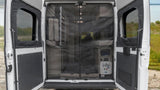 Rear view of an RV rental with double doors open, showcasing a screen and the camper van's cozy interior setup.
