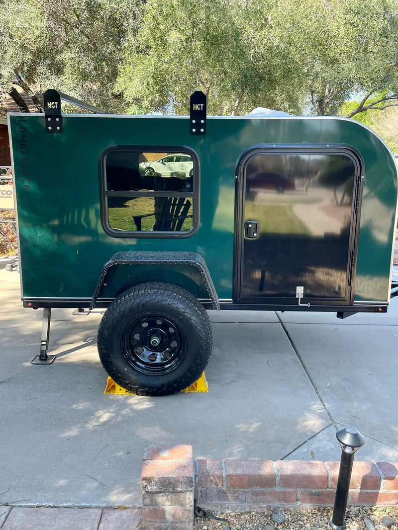  and chairs set up in a rugged desert mountain landscape.|Cozy RV rental bed with grey sheets — photo 4