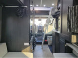 RV rental interior: View of a compact living space, showing the galley, ladder to a bed, and cockpit.