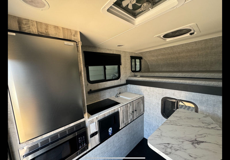  ready for adventure.|White Ford Super Duty truck with RV camper on a dirt forest trail. Perfect for your next rv rental adventure!|Inside a modern RV rental — photo 13