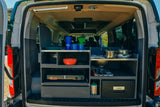 This RV rental camper van features a compact, fully-equipped kitchen with a stove, sink, and Dometic cooler, perfect for camping gear.