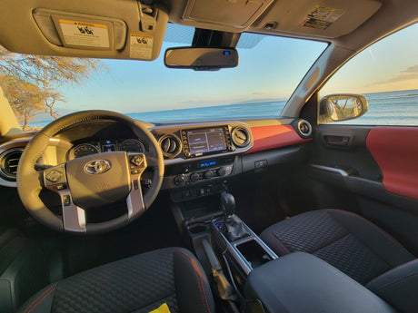 Toyota Tacoma interior, ocean view. Red accents on dash. Great for a scenic rv rental or travel experience.