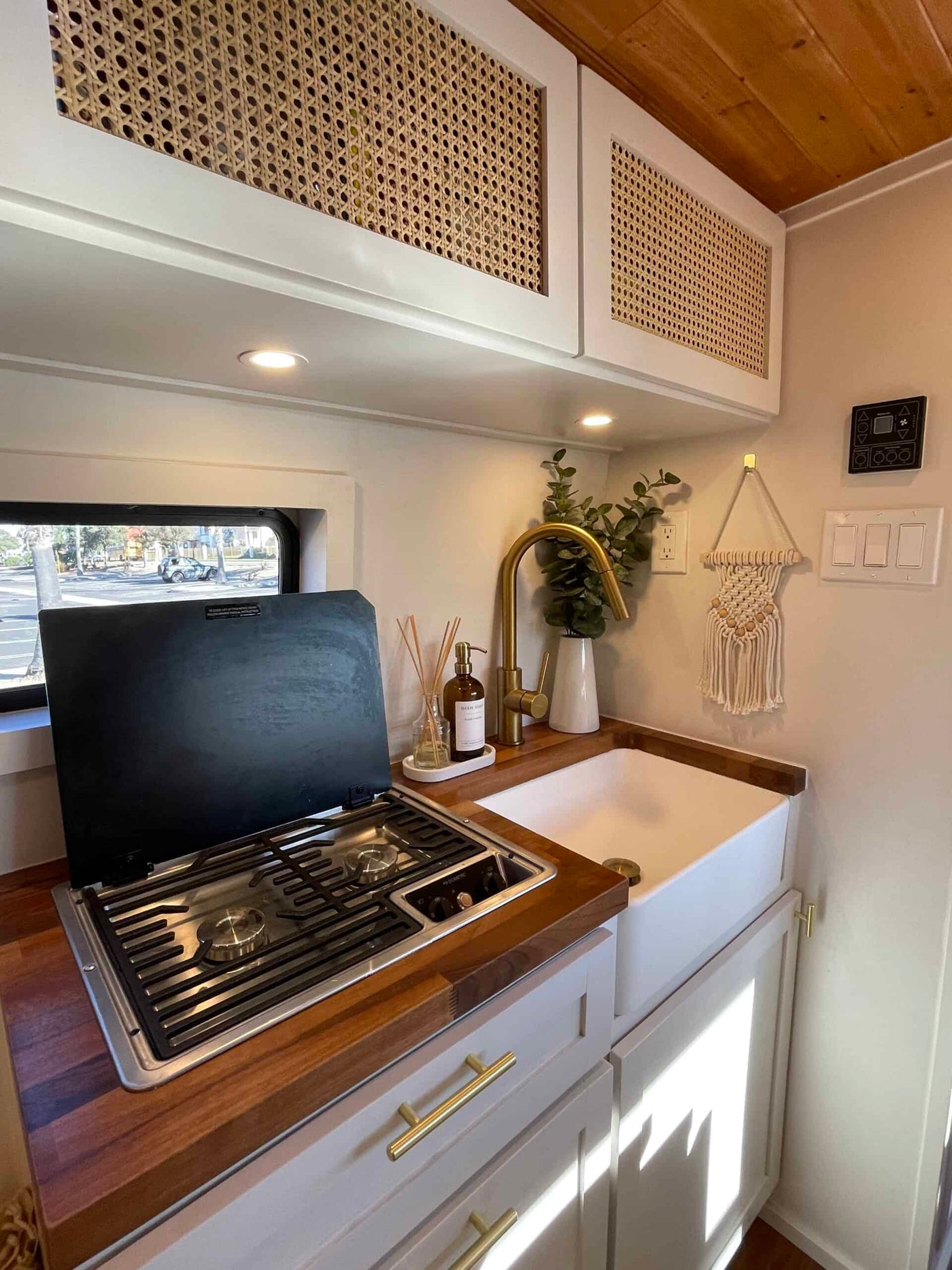  and palm trees for an outdoor adventure.|This rv rental camper van showcases a cozy bed & ample storage through its open rear doors — photo 8
