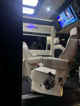 Luxury RV rental interior with comfy captain's chairs, TV, and ambient lighting, perfect for travel.