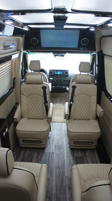 Step inside this RV rental: luxurious interior with quilted leather captain chairs, wood-style floor, and front entertainment.