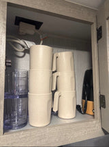  and green bed. Enjoy practical camper living.|Cozy RV rental interior featuring a compact kitchen