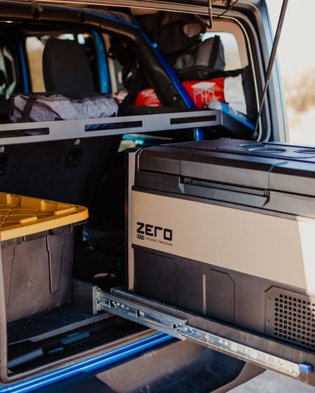 Optimized RV rental cargo: pull-out fridge, storage bins, and overhead shelf system ensure organized adventure travel.