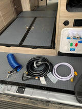 RV rental ready! Essential utilities and accessories for RV camping, including hoses, shore power cord, and water connection panel.