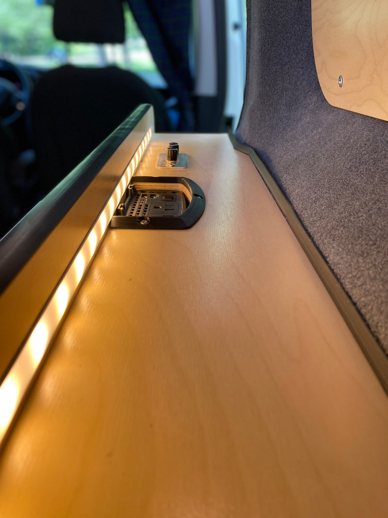 Detailed RV rental interior shot, showing custom wood paneling, bright LED strip lighting, and a built-in charging station. — photo 14