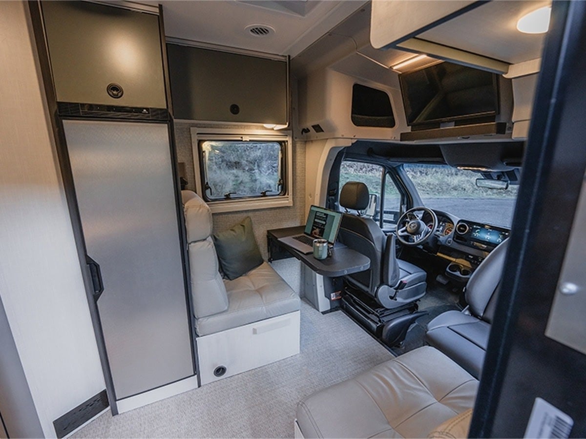  and rear sleeping quarters.|Spacious RV rental bedroom showcasing a bed with green bedding — photo 11