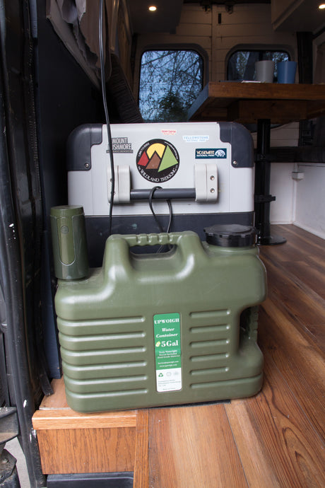 RV rental with camping essentials: a large cooler, 5-gallon water container, and gear for national park adventures.