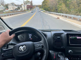 Driver's view from an RV rental, navigating a road with homes. Dashboard shows 56°F, 93 miles, and GPS to Maple Ave.