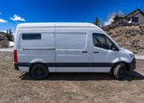 White Mercedes-Benz Sprinter van, a perfect RV rental option. Parked outdoors under a clear blue sky.