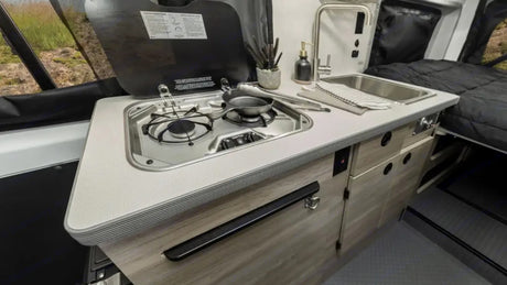  and overhead storage.|Inside a cozy RV rental: a grey quilted mattress