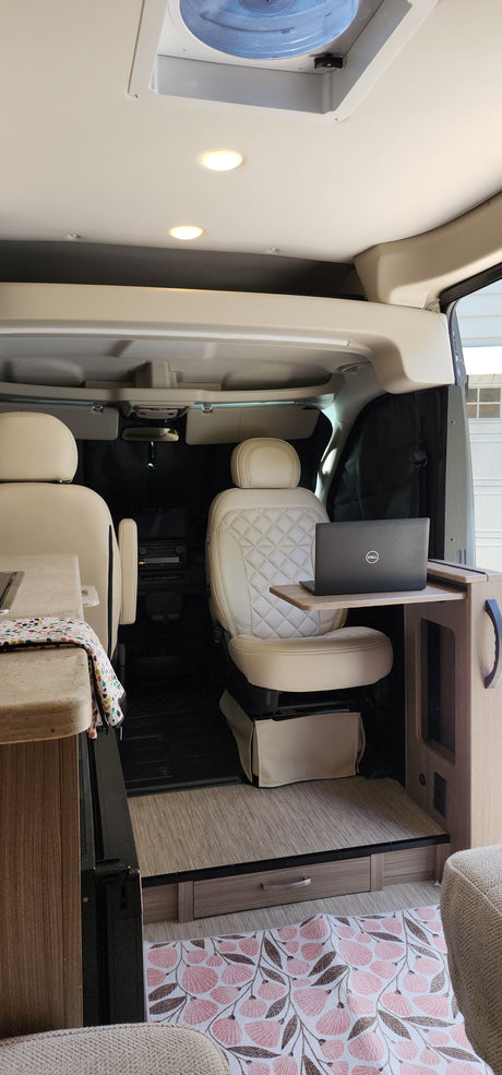 Step inside this modern RV rental with swiveling cream seats, a laptop workstation, and light wood flooring for your next adventure.