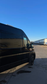 Black Ram ProMaster cargo van by train tracks on a clear day, ready for your next rv rental conversion project.
