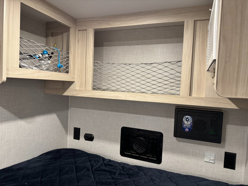  and practical netted storage for a comfortable camper experience.|Cozy RV rental interior showing a bed — photo 9
