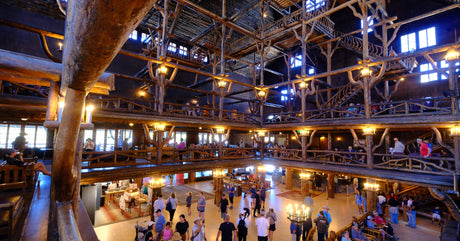 Explore the multi-story log lobby of a grand lodge, bustling with guests. A quintessential stop for your RV rental journey.