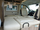 RV rental: Inside a camper van featuring a convertible bed, a window, and swiveled front seats creating a versatile living area.