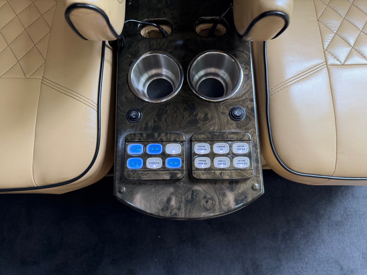 Luxury RV rental interior with a detailed control panel for lights, shades, and speakers, alongside convenient cup holders. — photo 18