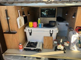 RV rental's compact tailgate kitchen: cooler, portable stove, water system, & camping essentials for outdoor adventures.