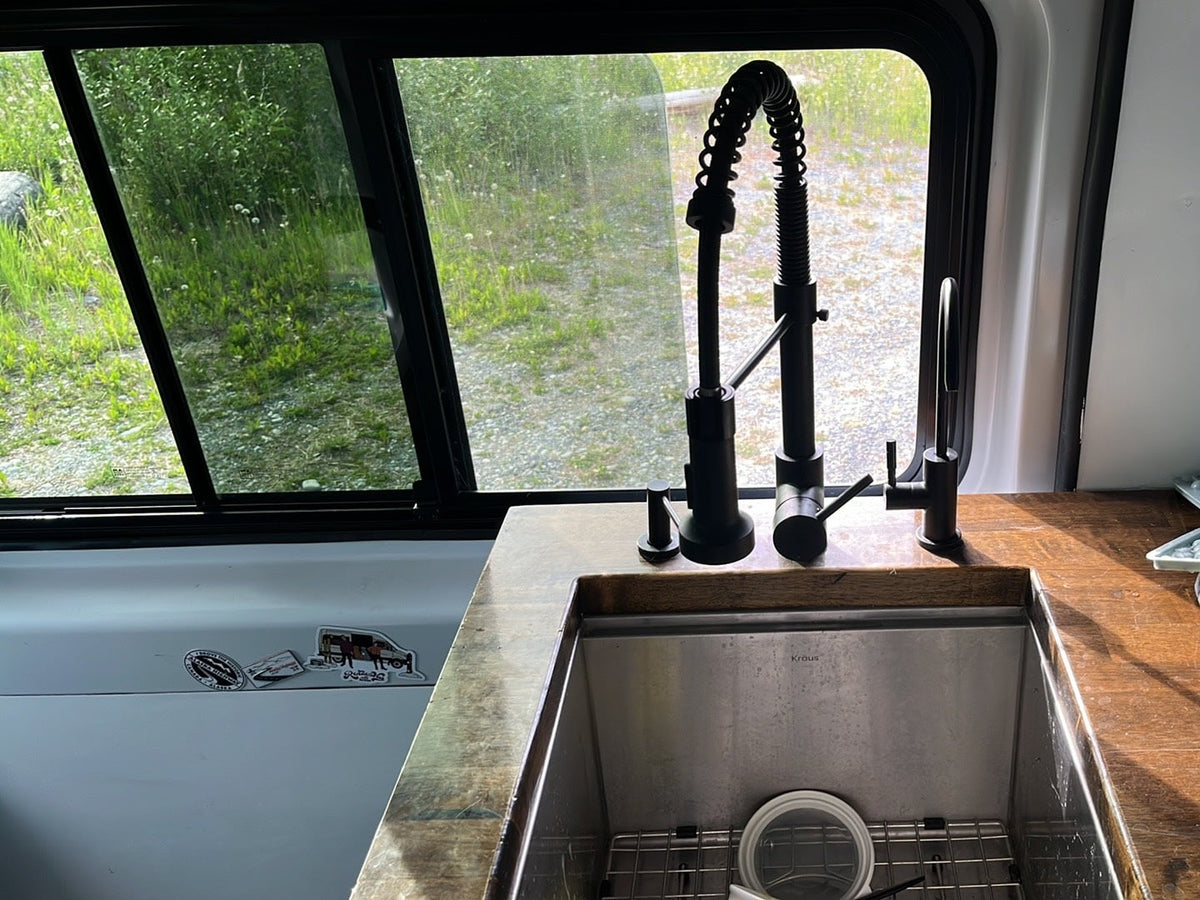 and custom blue cabinetry with a unique ceiling.|RV rental: Van interior with a cozy bed — photo 7