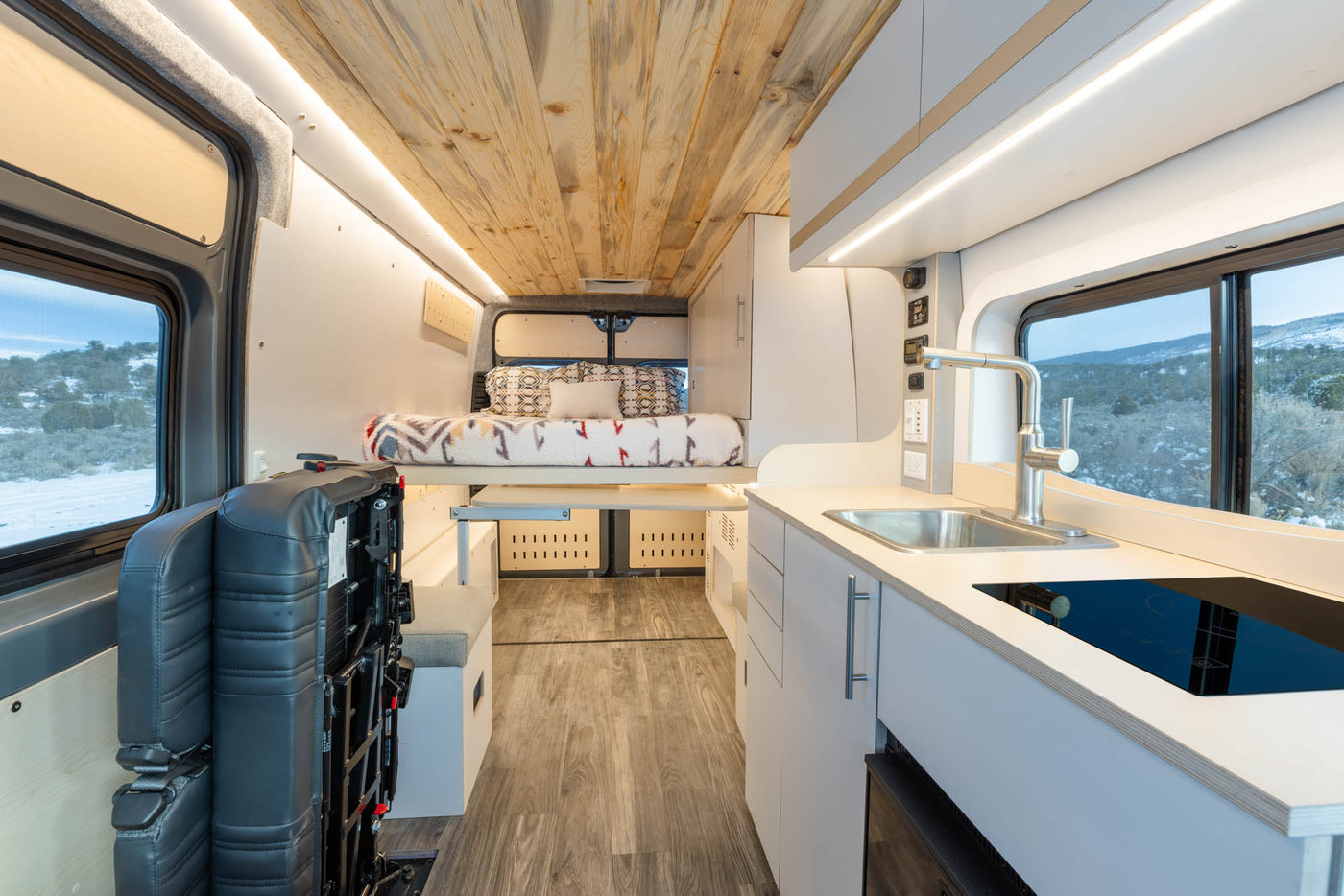  is parked under a stunning starry night sky.|Inside an RV rental kitchen cabinet: neatly organized light-colored dishes & clear glasses.|Green single-serve coffee maker with a K-cup — photo 3