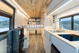 Spacious RV rental interior: modern camper van with kitchen, bed, and panoramic windows for a comfortable adventure.