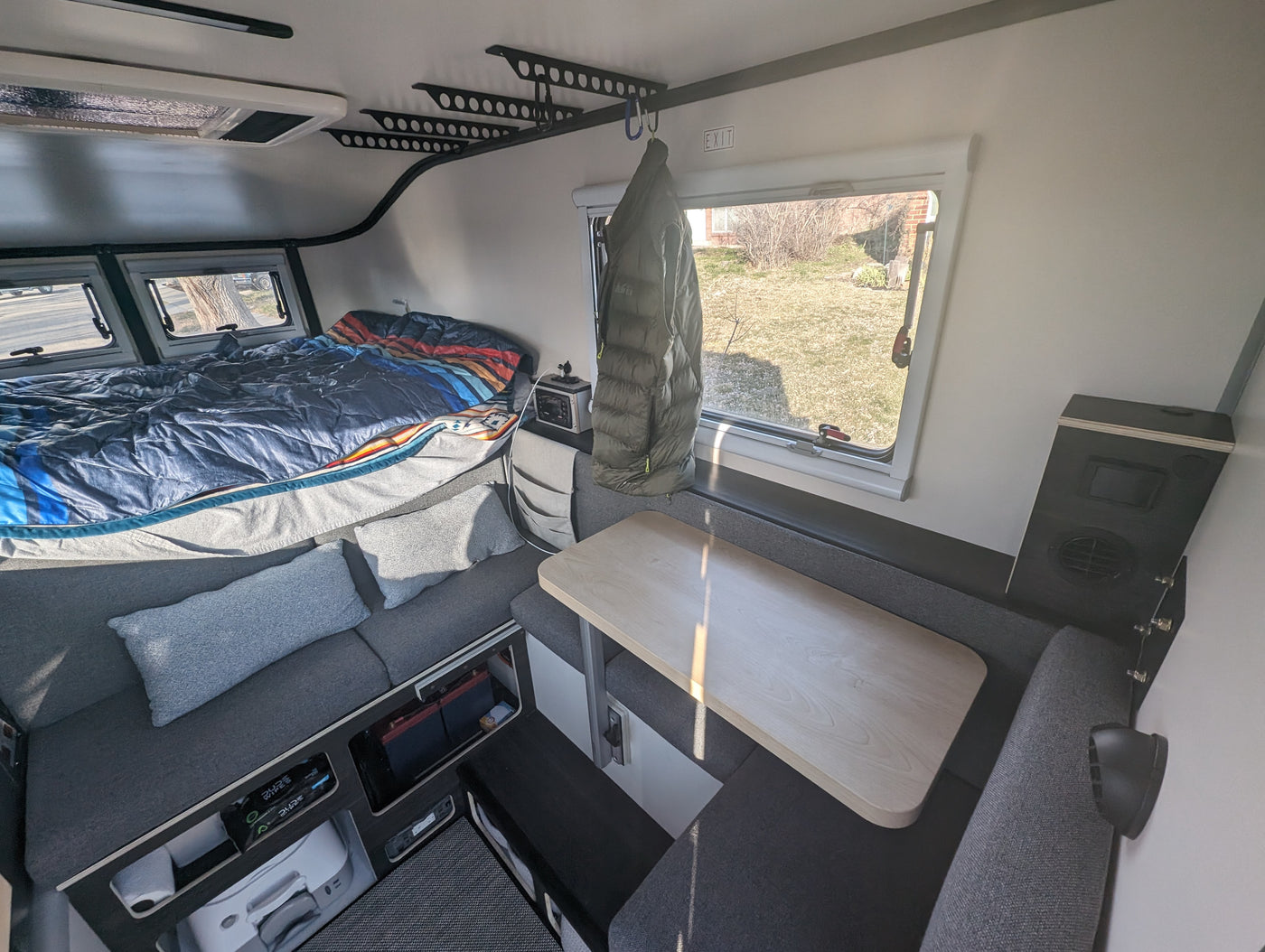 Cozy RV rental interior with a bed, dinette, and ample built-in storage for travel. — photo 5