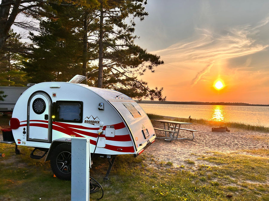  and practical amenities for travel.|Cozy rv rental: feet up on bed