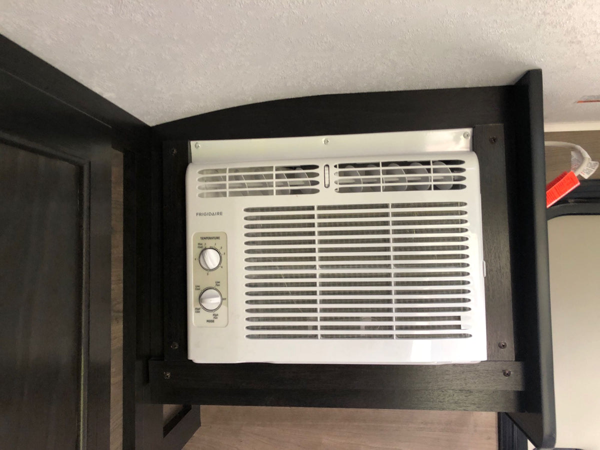 RV rental interior with a white Frigidaire AC unit. Displays temperature and fan controls, ensuring comfortable climate control. — photo 11