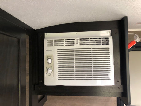 RV rental interior with a white Frigidaire AC unit. Displays temperature and fan controls, ensuring comfortable climate control.