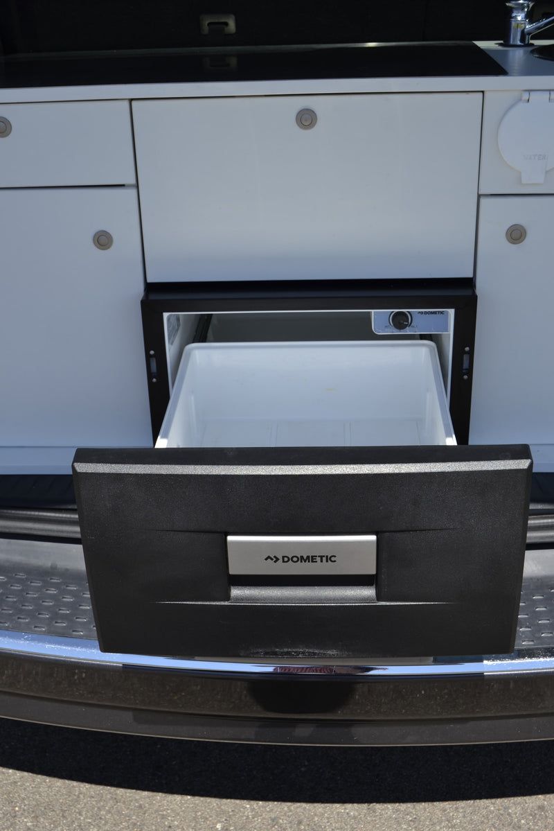  offers van life comfort on nature road trips.|RV rental: A vehicle's trunk holds a compact camper kitchen module with sink — photo 10