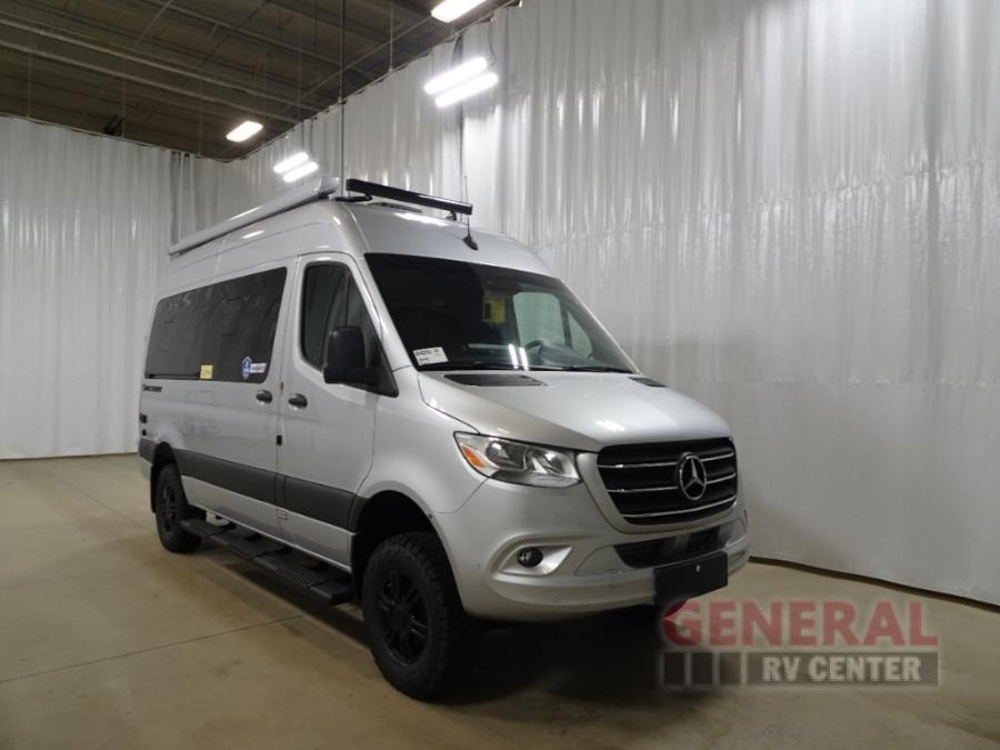 Silver Mercedes-Benz Sprinter camper van, ideal for your next adventure rv rental. Features roof rack and off-road tires.