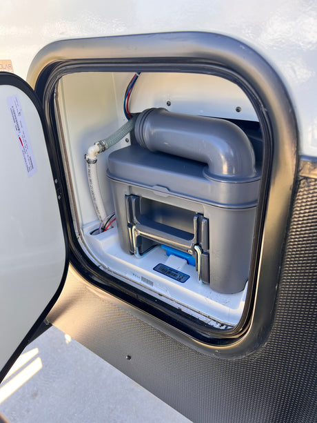 RV rental maintenance: A cassette toilet waste tank is visible in an RV's exterior compartment for easy servicing.