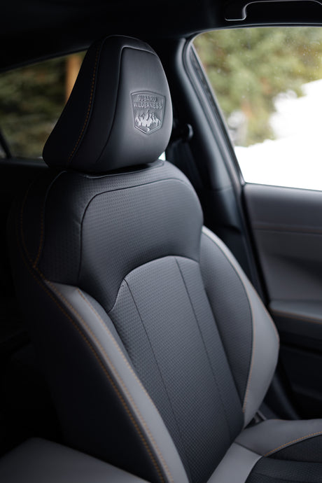 Subaru Wilderness car seat, detailed headrest logo & orange stitching. Premium interior comfort for your next RV rental adventure.