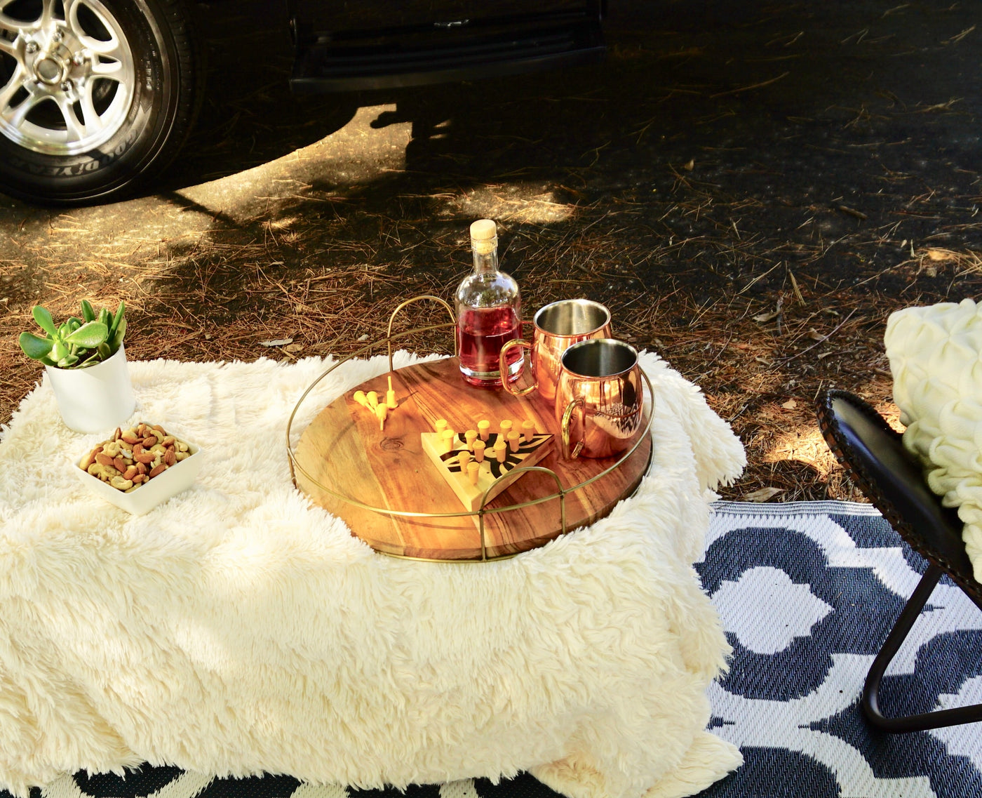 A cozy outdoor lounge area with a fluffy blanket, nuts, drinks, and a game, set beside an RV rental. — photo 5