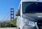 White RV rental van facing Golden Gate Bridge in San Francisco. Ready for your next travel adventure under a clear sky.