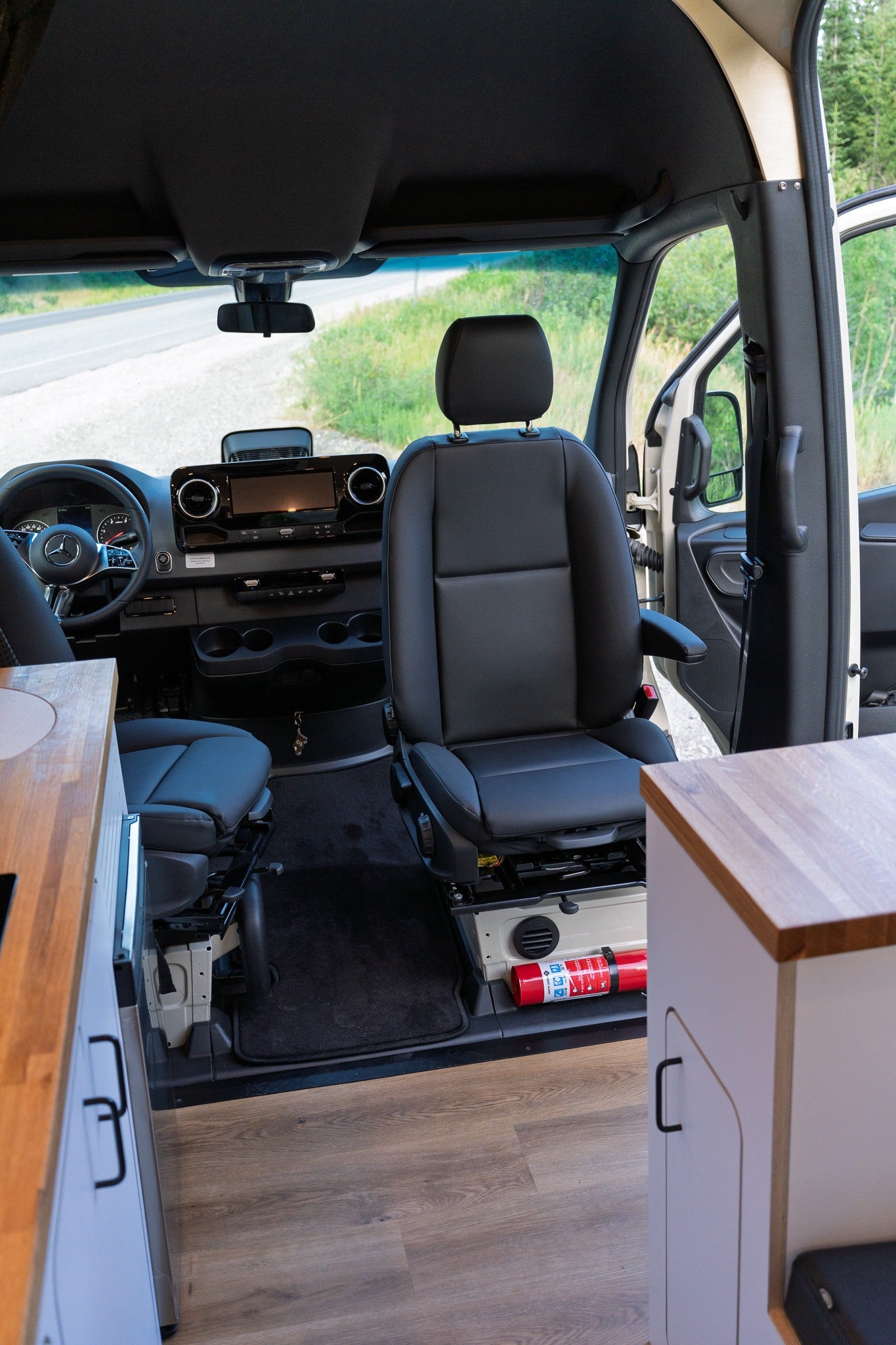 Experience this RV rental's inviting interior. Featuring a functional dashboard, rotating seats, and wood finishes.