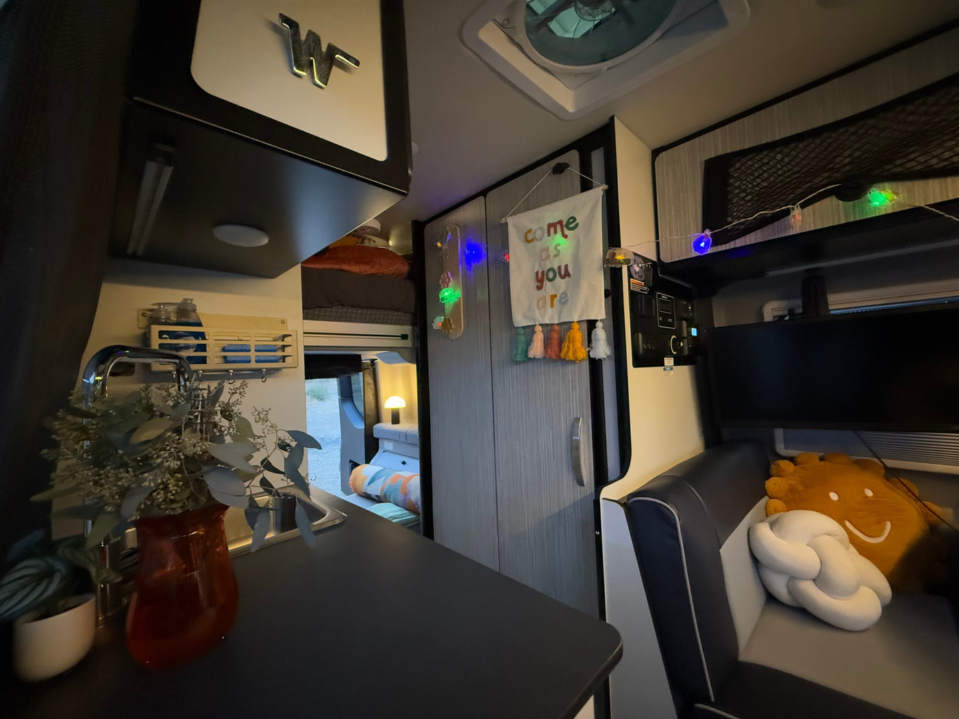  and table surrounded by red rock formations.|Inside a cream rv rental van with rear doors open — photo 32