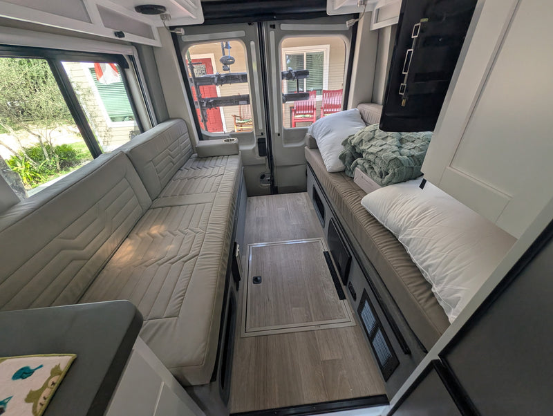  shown from the front with a unique mountain-themed license plate frame.|RV rental bathroom: compact wet bath with toilet — photo 10
