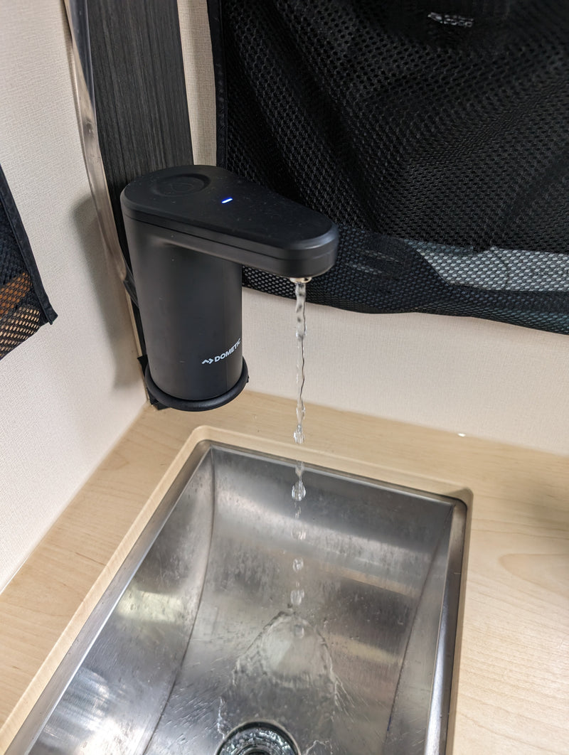 RV rental: Water flows from a modern Dometic faucet into a compact stainless steel sink, ideal for small spaces. — photo 11