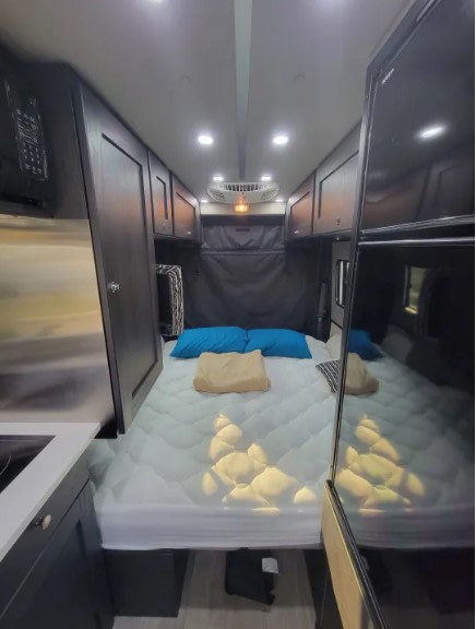  and a convenient bedside counter with essentials.|RV rental: Top-down interior floor plan. Shows camper's main bed — photo 8