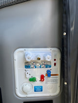 RV rental water system control panel with multiple colored valves and connections for water management.